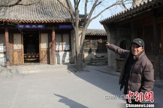 图为85岁得王绪老人指着文昌宫的正殿对记者介绍说，“鸡鸣驿是国家的文物，一定要保护好”。