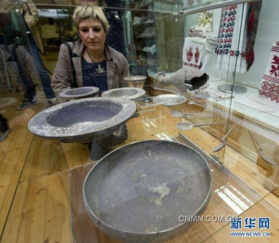 3月29日，在克罗地亚温科夫齐市博物馆，一名记者观看新近出土的古银器。