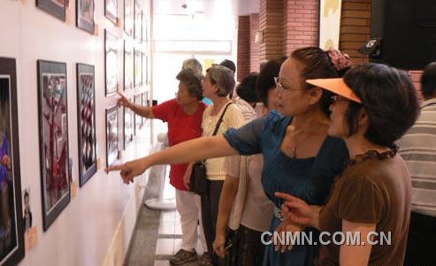 宾客们在观看书画摄影展。