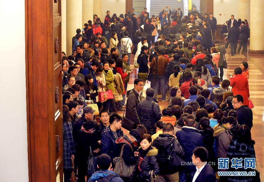 2月28日，大批记者聚集在全国政协礼堂大厅内排队等候领取证件。