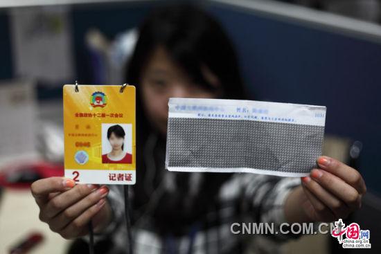 2013年2月28日，北京，参与全国政协十二届一次会议报道的内地记者展示记者证和密码函件。