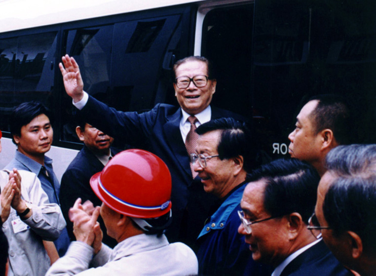 “同志们好！”“大家好！”迈出车门的江泽民向激动沸腾的西南铝职工微笑地点头，爽朗地问好，亲切地挥手致意。（李影摄）